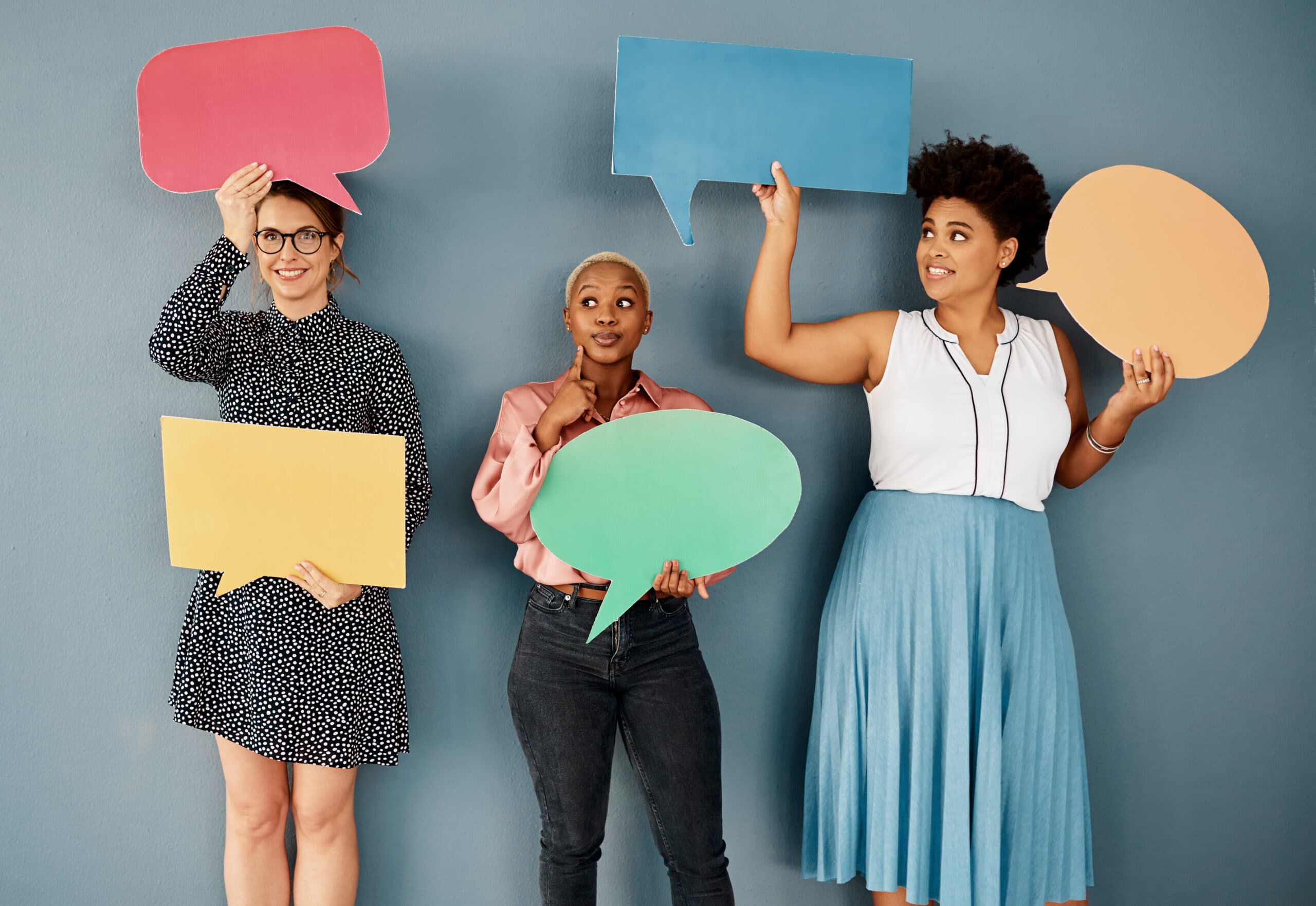 Women holding colorful speech bubbles